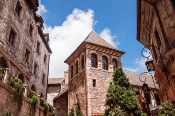 historic building in a medieval style on the background of blue sky. In the center is the tower facade of the castle