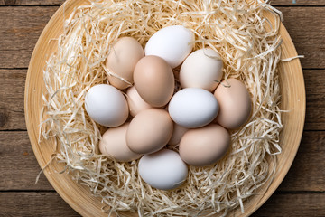 Poster - Organic chicken eggs in nest on wooden background. Food photography