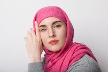 Close-up portrait of a muslim woman wearing a head scarf hijab and smilling. Isolated.