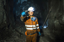 Miner In The Mine. Well-uniformed Miner Inside Mine Raising Thumb, Conceptual Photo