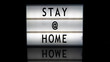 Stay @ home letters on a light box on reflective surface
