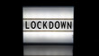 Lockdown letters on a light box on reflective surface