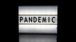 Pandemic letters on a light box on reflective surface