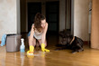 © Вячеслав Думчев - The girl washes the floor after the dog. The dog lies and looks guilty