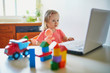 © Ekaterina Pokrovsky - Happy toddler girl with laptop and toys