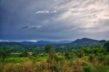 clouds gather above the hills and rain forest of sub-saharan west africa in the bush of ghana.