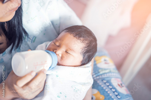 Cuadros en Lienzo Mother holding new born baby in arms feeding bottle of milk, motherhood parentho