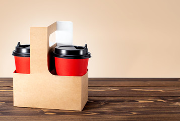 Wall Mural - Card-box basket with coffee on wooden table with copy space. Fast food concept. Coffee to go.