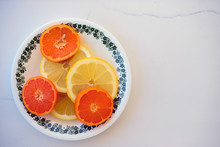 Orange And Lemon Slices On A Plate Set On A White Background
