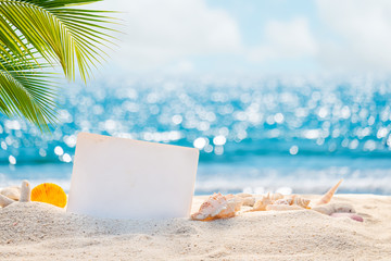 Sandy beach with empty paper card for message design. blur sea on background. Tranquil beach scene for travel inspirational. Summer exotic holiday and vacation concept for tourism relaxing.