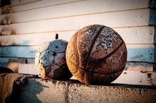 Close-up Of Damaged Soccer And Basketball On Retaining Wall