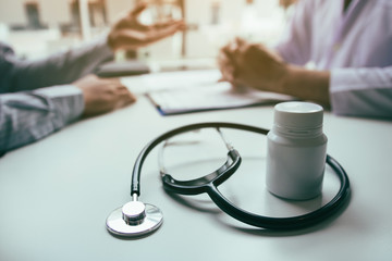 Close up stethoscope and doctor talking the patient at clinic while using the tablet explaining the patient condition and the treatment result.