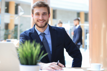 Portrait of young man sitting at his desk in the office.