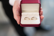 Cropped Hand Holding Wedding Rings In Box