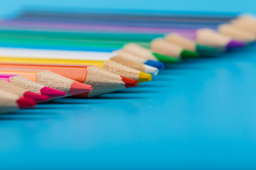 Close-up of set of colorful pencils on blue background with copy space