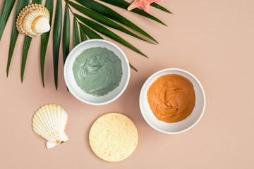 Clay masks in bowls for face treatment with tropical palm leaf, top view. SPA natural organic cosmetics, facial skincare concept