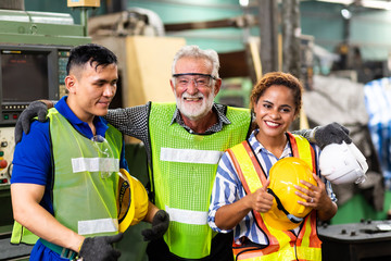 Wall Mural - Man and Woman engineering wearing safety goggles and hard hats giving high five and celebrating success. Metal lathe industrial manufacturing factory