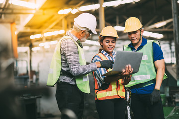 Wall Mural - Professional Mechanical Engineer team Working on Personal Computer at Metal lathe industrial manufacturing factory. Engineer Operating  lathe Machinery. Product quality Inspection