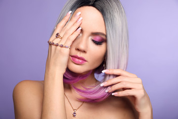 Wall Mural - Beautiful lady presents amethyst ring and bracelet jewelry set. Woman portrait with ombre bob short hairstyle and manicured nails. Beauty makeup. Gorgeous model isolated on purple background.
