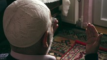 Elderly Turkish Muslim Man Wearing Prayer Cap Prays To Allah By Raising His Hand