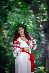 Wall Mural - beautiful woman in wreath of wild flowers of flowers in sunny day.