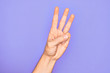 © Krakenimages.com - Hand of caucasian young man showing fingers over isolated purple background counting number 3 showing three fingers
