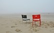 Chairs On Sandy Beach Against Sky