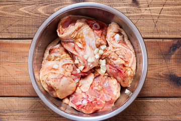 Step by step cooking of baked chicken with vegetables, step 2 - marinating chicken thighs, selective focus