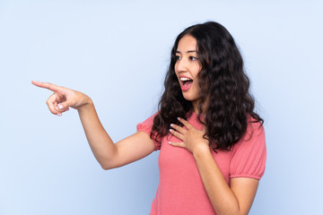 Canvas Print - Mixed race woman wearing a sweater over isolated blue background pointing finger to the side