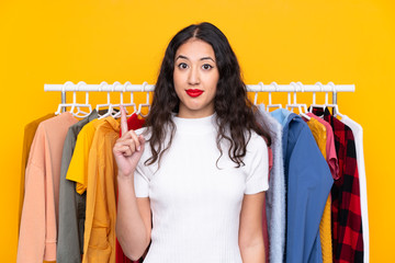 Wall Mural - Mixed race woman in a clothing store pointing with the index finger a great idea