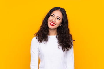 Wall Mural - Mixed race woman over isolated yellow background laughing and looking up