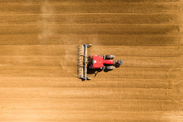 Pre seeding flattening roller Tractor working in a field, Aerial image.