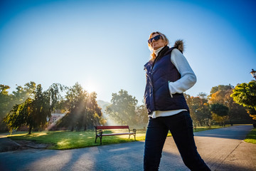 Wall Mural - middle-aged woman walking in city park