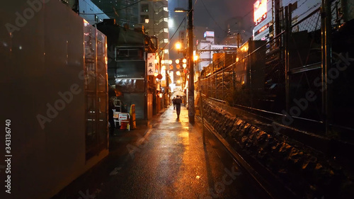 Fotografía Illuminated Footpath Amidst Buildings At Night