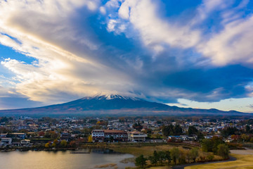 Wall Mural - Japan. Volcano of Fuji in autumn day. Kawaguchiko Lake. Clouds over Mount Fujiyama. The city at the foot of the volcano. Landscape of the Japanese city. Panorama of Mount Fuji. Regions of Japan.