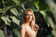© liliyabatyrova - Woman in swimsuit on tropical plants background