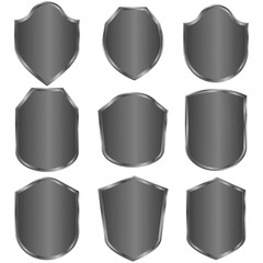 Poster - Gray shields with a black tint with the effect of overflow, without inscriptions on a white background. Shields of various shapes with a unique design. Vector graphics. Stock Photo.