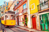 Fototapeta Uliczki - Yellow vintage tram on the street in Lisbon, Portugal. Famous travel destination