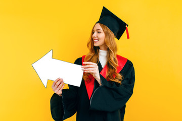 Wall Mural - A happy, graduate holds a clean paper layout, pointing to a copy of the space on a yellow background