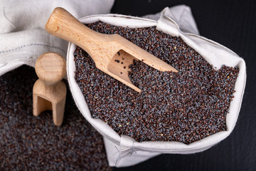 Tasty and clean poppy seeds in fabric bags. Ingredients for delicious desserts and other dish on the table.