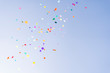Colorful confetti thrown against blue sky celebration sunshine party