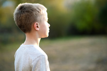 Child Boy Standing Outdoors On Summer Sunny Day Enjoying Warm Weather Outside. Rest And Wellness Concept.