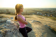 © bilanol - Woman hiker leaning on a big rock enjoying warm summer day. Young female climber resting during sports activity in nature. Active recreation in nature concept.