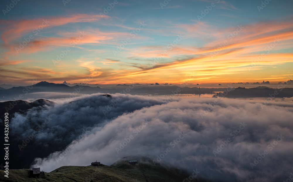 Scenic View Of Clouds Covered Mountains At Sunset - obrazy, fototapety, plakaty 