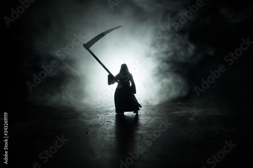 Fotografía Death with a scythe in the dark misty forest
