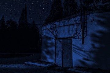 Mountain night landscape of building at forest at night with moon or vintage country house at night with clouds and stars. Cold autumn night