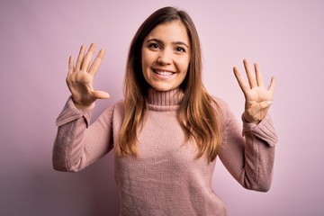 Sticker - Beautiful young woman wearing turtleneck sweater over pink isolated background showing and pointing up with fingers number nine while smiling confident and happy.