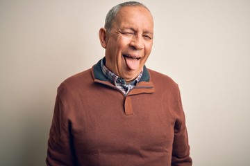 Sticker - Senior handsome man  wearing elegant sweater standing over isolated white background sticking tongue out happy with funny expression. Emotion concept.