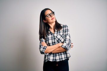 Wall Mural - Young brunette woman with blue eyes wearing casual shirt and glasses over white background looking to the side with arms crossed convinced and confident