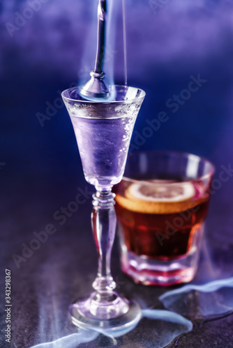 Classic alcoholic cocktails in shot glasses or shooters on dark blue background. Studio shot of drink in freeze motion, burning cocktail, stylized